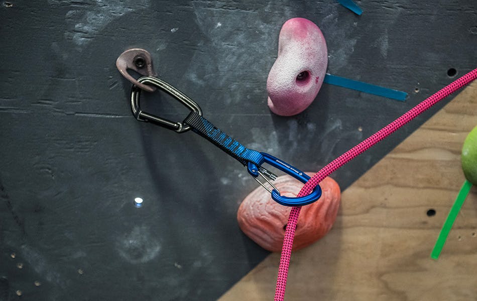 Rope clipped in quickdraw in climbing gym.