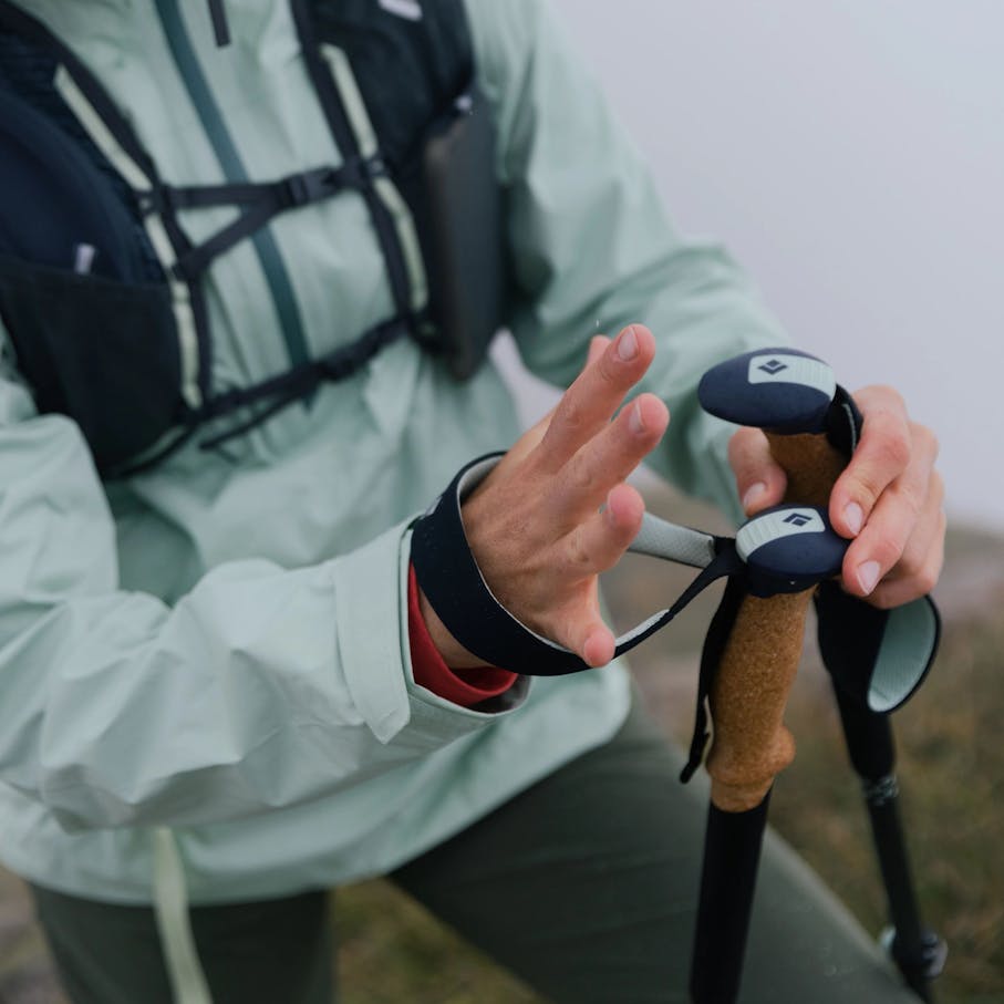 Female hiker putting on the wrist straps of Black Diamond Pursuit poles