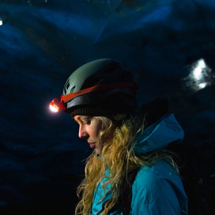 Local Icelander wearing a Black Diamond headlamp over their helmet in an Ice cave in Iceland.  