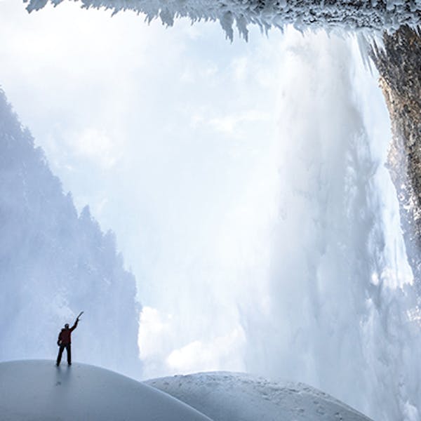 Climber surrounded by snowy landscape.