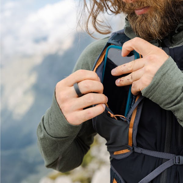 A hiker stashes his phone in the sternum pocket on his Pursuit 15 hiking pack. 