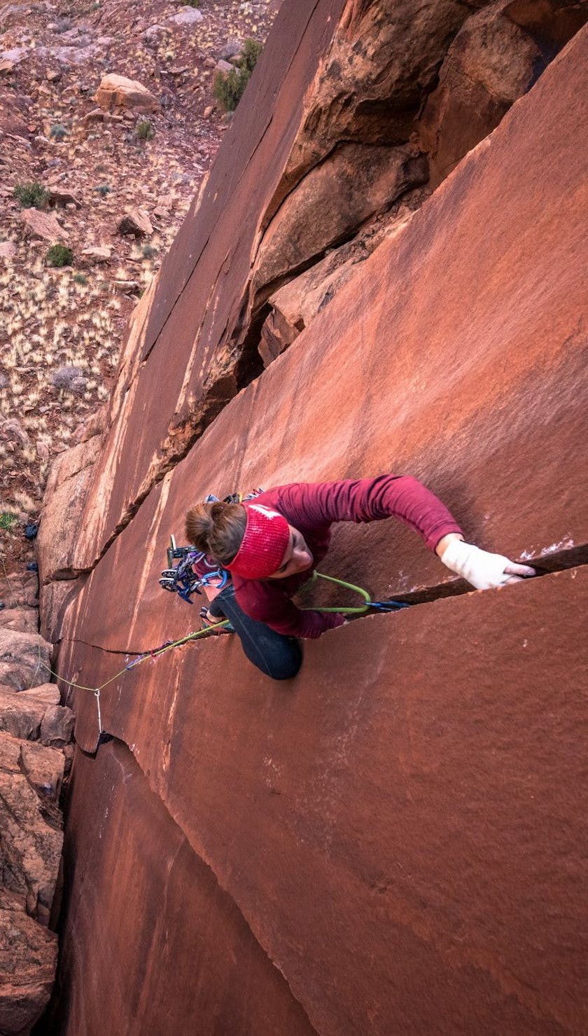 Woman climbs up crack climb while wearing BD crack gloves