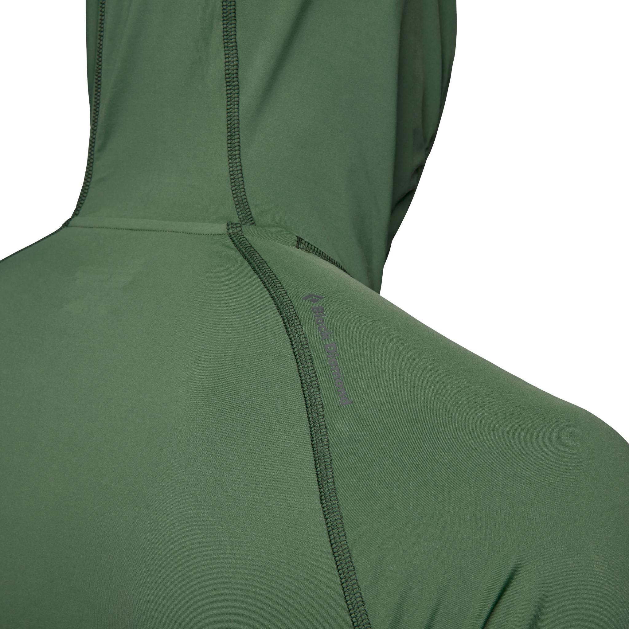A model faces away wearing a green Alpenglow Pro Hoody with the hood up.