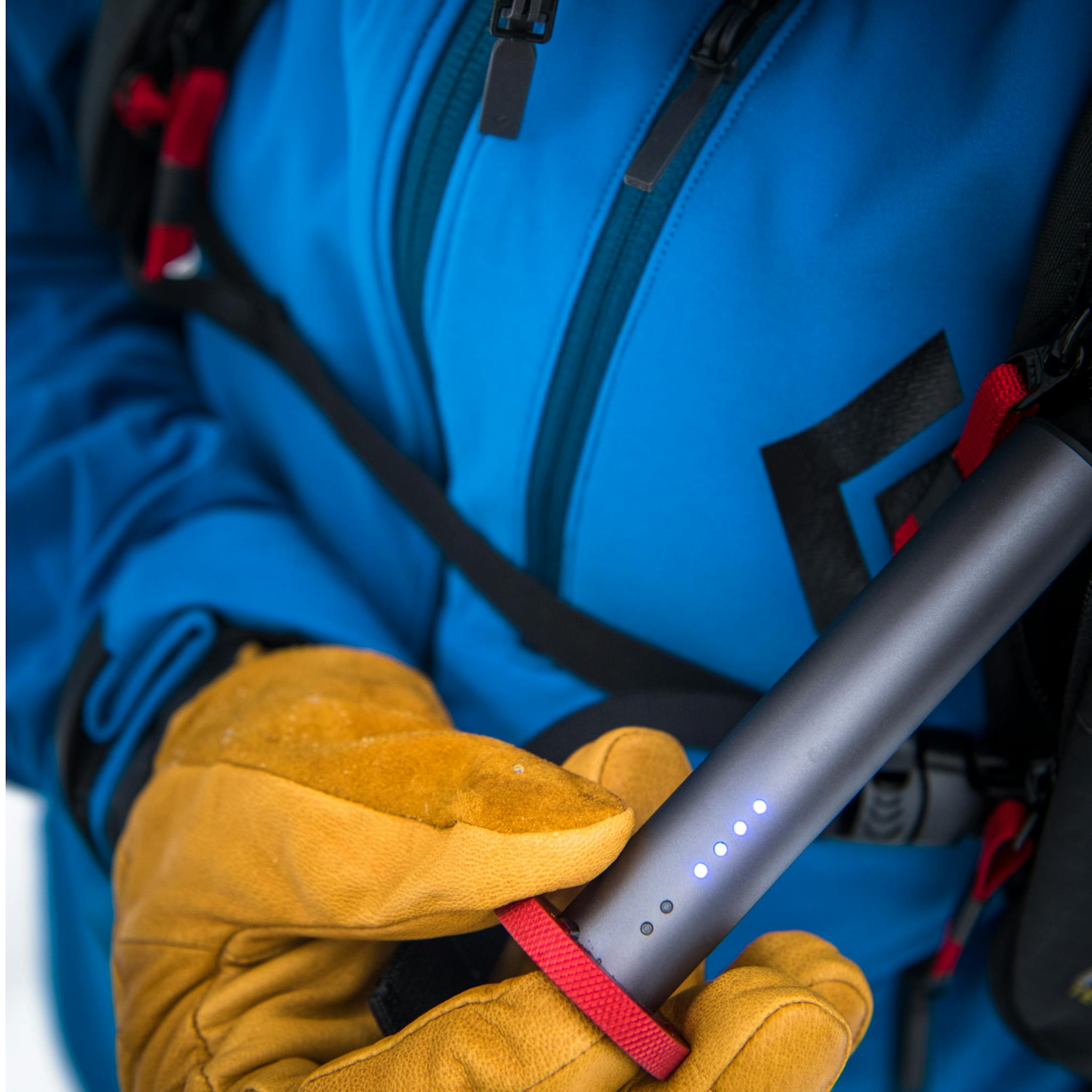 A skier checks his deploy trigger on his Jetforce Pack