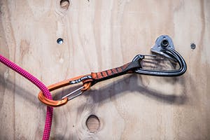 Rope clipped in quickdraw in climbing gym.