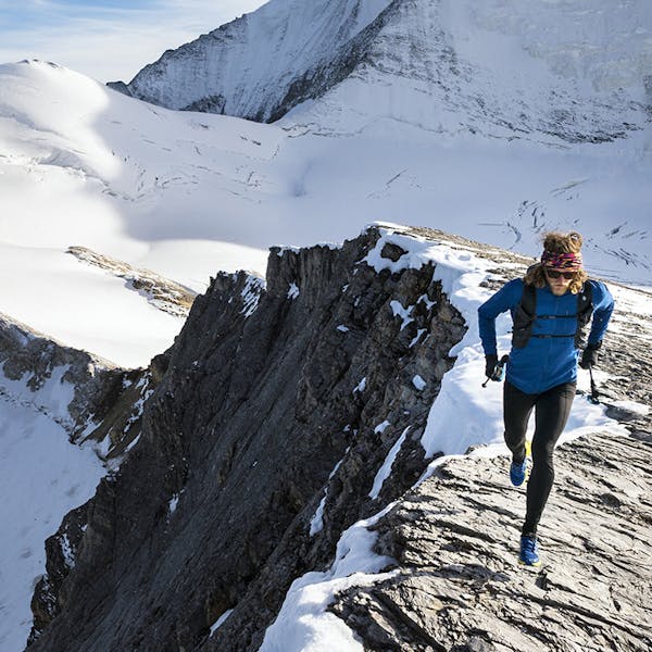 Joe running on a snowy rocky ridge