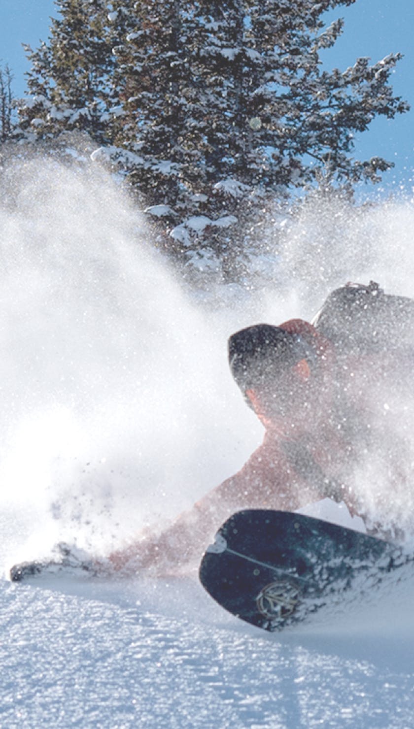 BD Athlete Bjorn Leines carving his snowboard through powder | avalanche airbag | Black Diamond Jetforce