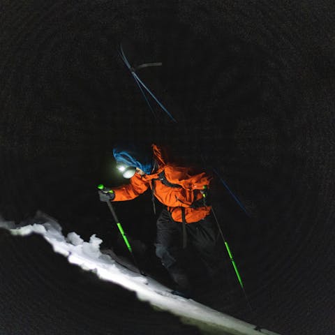 Un skieur bootpacks par Black Diamond lampe frontale dans les heures sombres du petit matin.