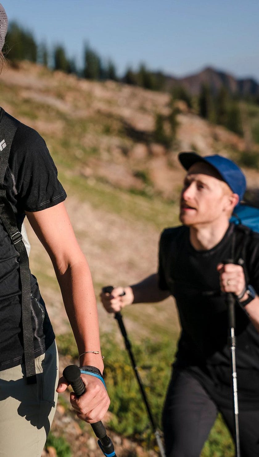 Mary McIntyre wearing a W Flux Merino shirt while hiking with a man outside
