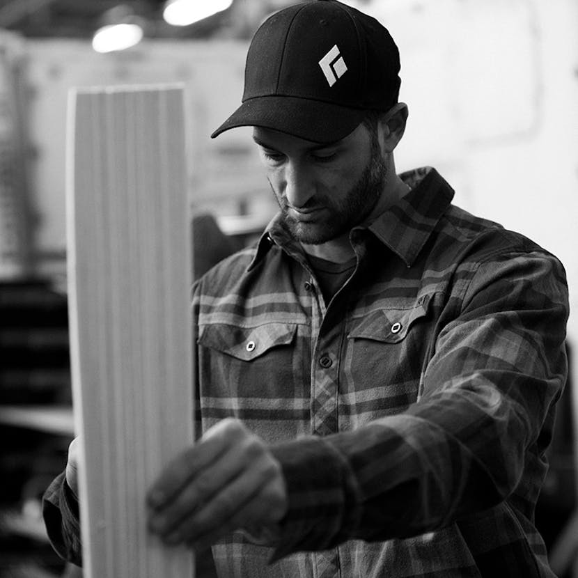 man inspecting skis