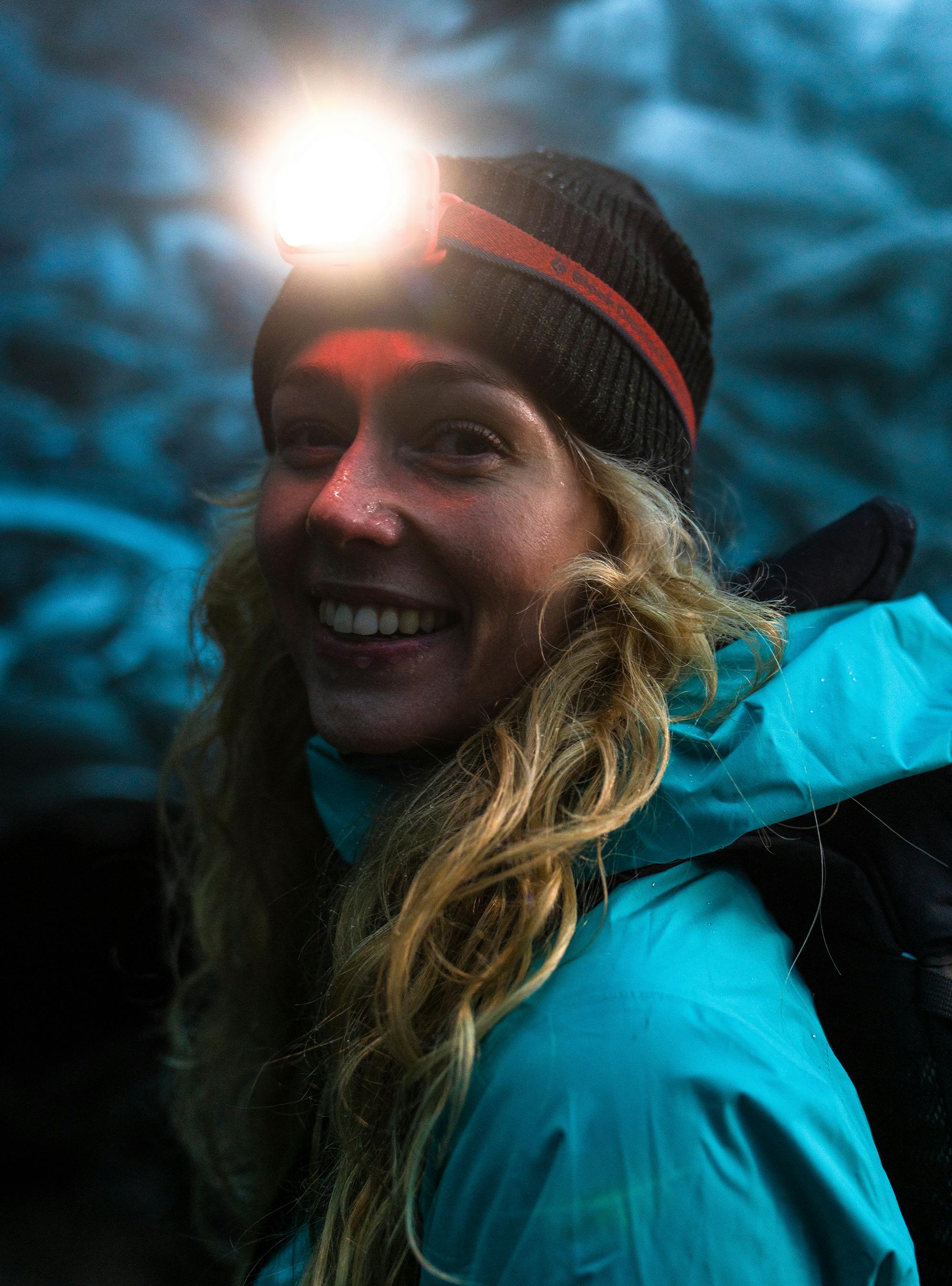 A loan hiker wearing a Black Diamond Storm 400-R headlamp to explore an ice cave. 