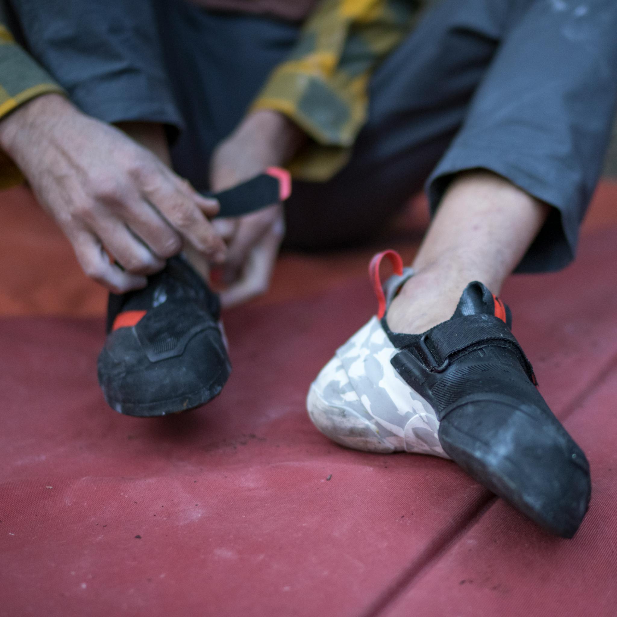 A climber velcro's his Method S Climbing shoes.