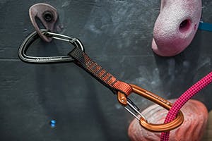 Rope clipped in quickdraw in climbing gym.