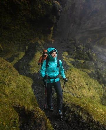A couple of hikers wearing Black Diamond Rain Shells to hike to a waterfall on a cold drizzling day.