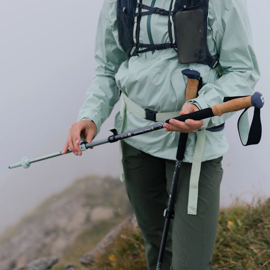 Hiker changing the length of a Pursuit pole using the FLicklock System in a foggy environment
