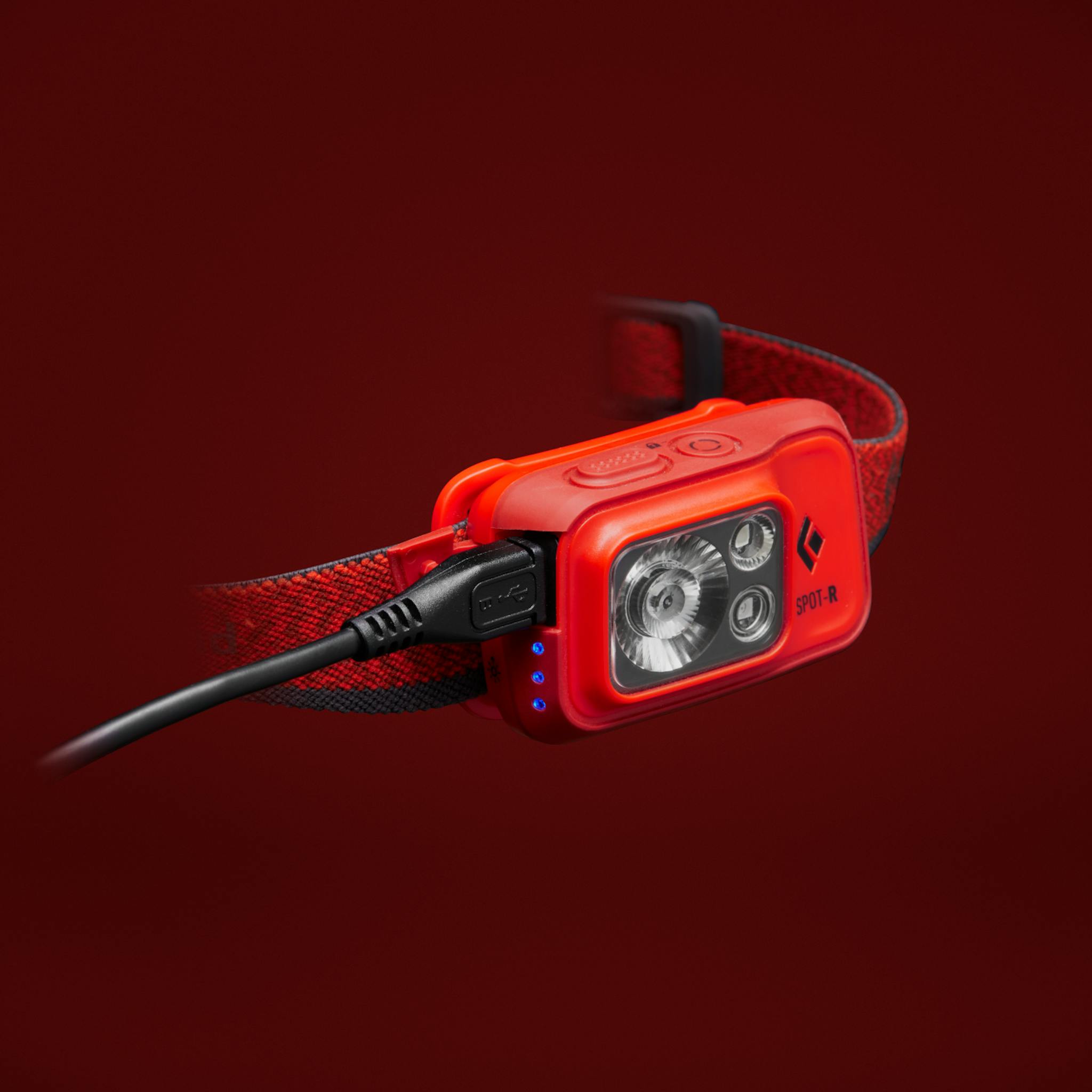 A red Spot 400 R Headlamp plugged into a micro USB