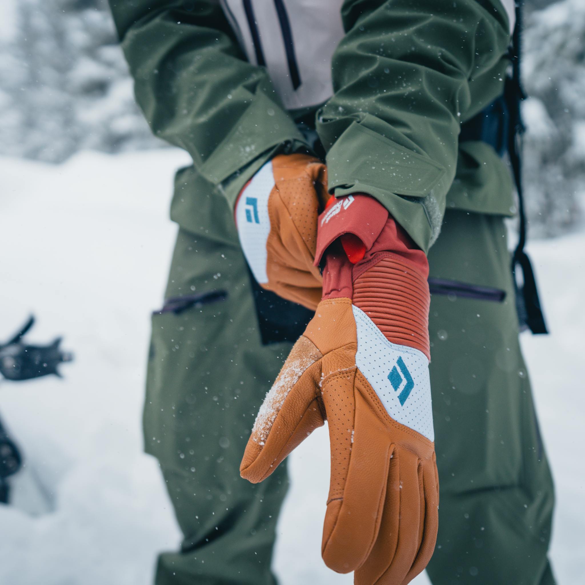 A skier pulls on a pair of Women's Impulse Gloves