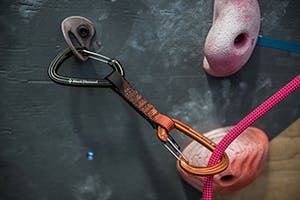 Rope clipped in quickdraw in climbing gym.