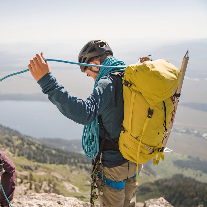 Photograph by Christian Adam of a man flaking a rope with a woman overlooking a mountain lake | Climbing Packs | Climbing rope bag