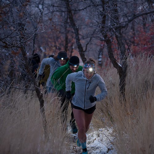 Group of people running at dusk with headlamps on
