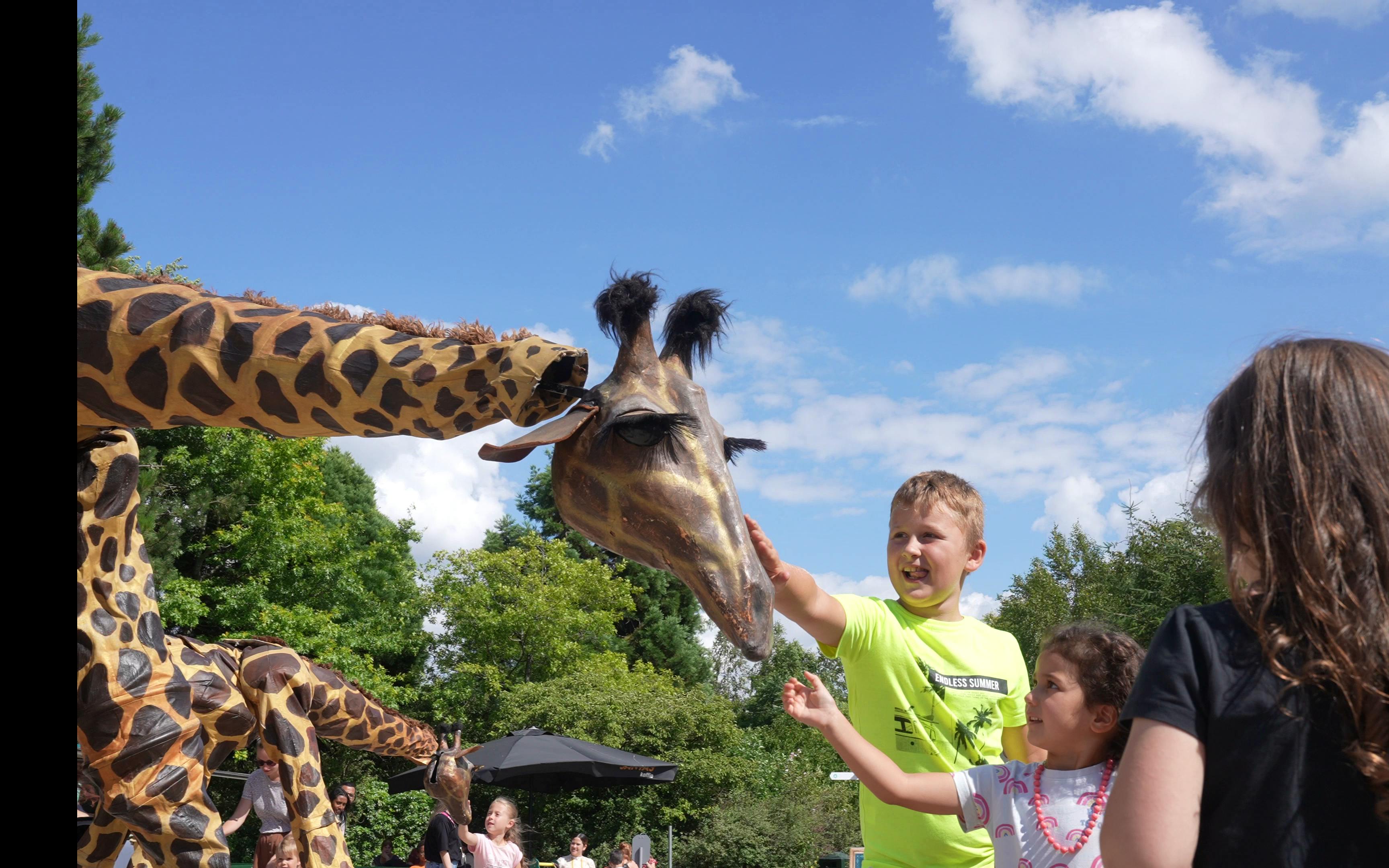 Kind aait giraffe steltloper op zomeravond.