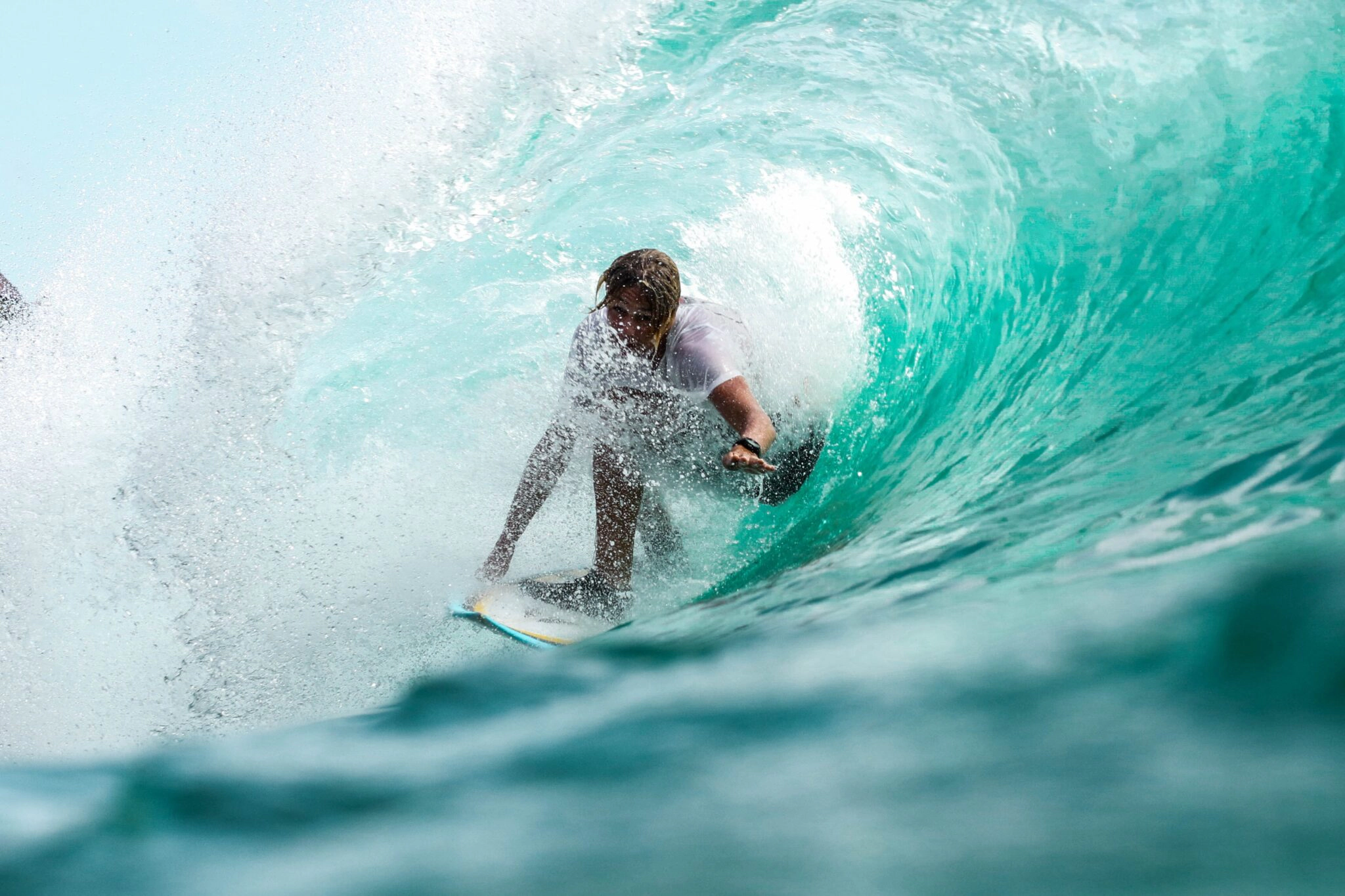una persona che fa surf all'interno di un'onda: ecco 5 mete da non perdere per fare vacanze sportive