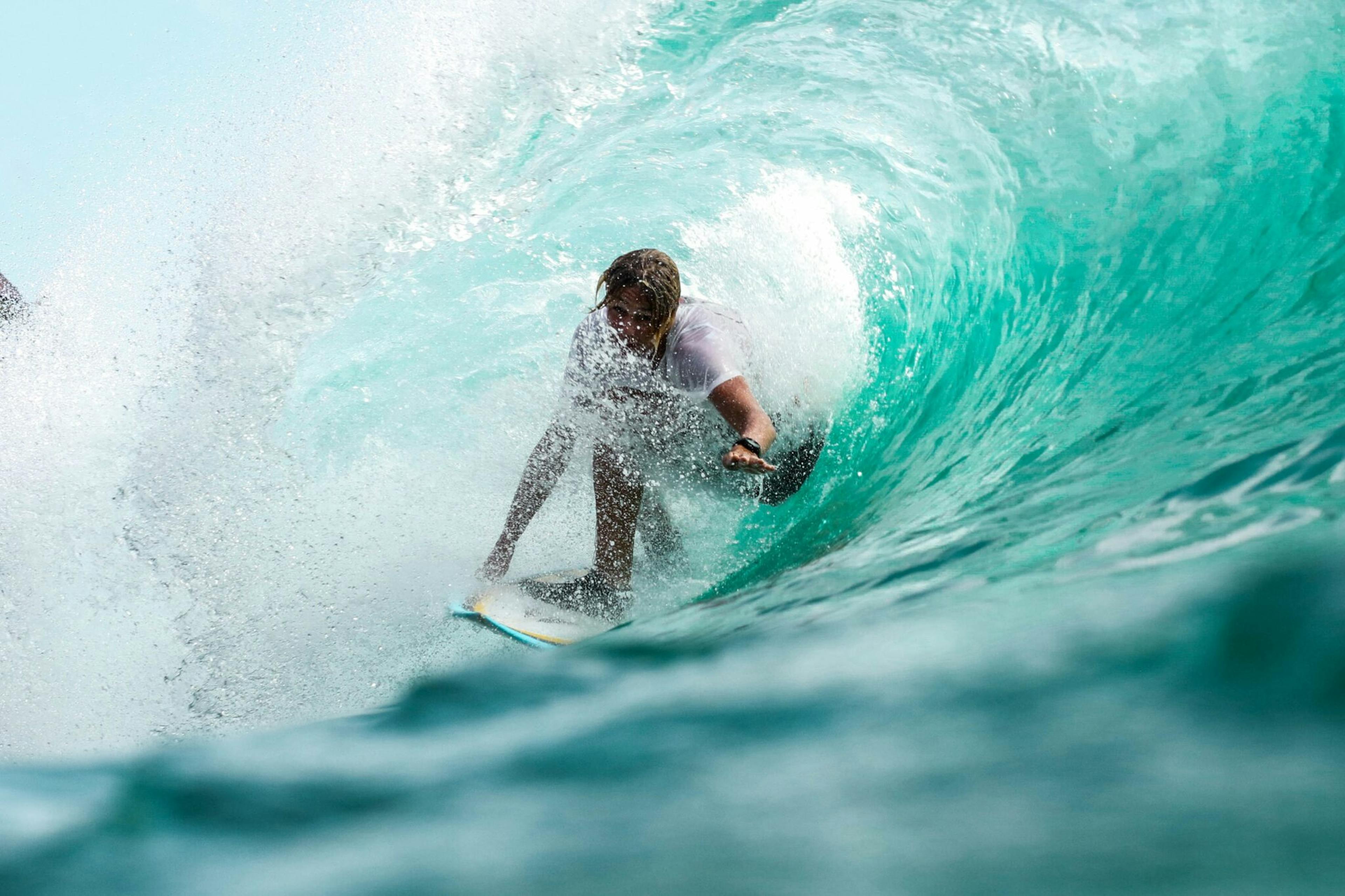 una persona che fa surf all'interno di un'onda: ecco 5 mete da non perdere per fare vacanze sportive