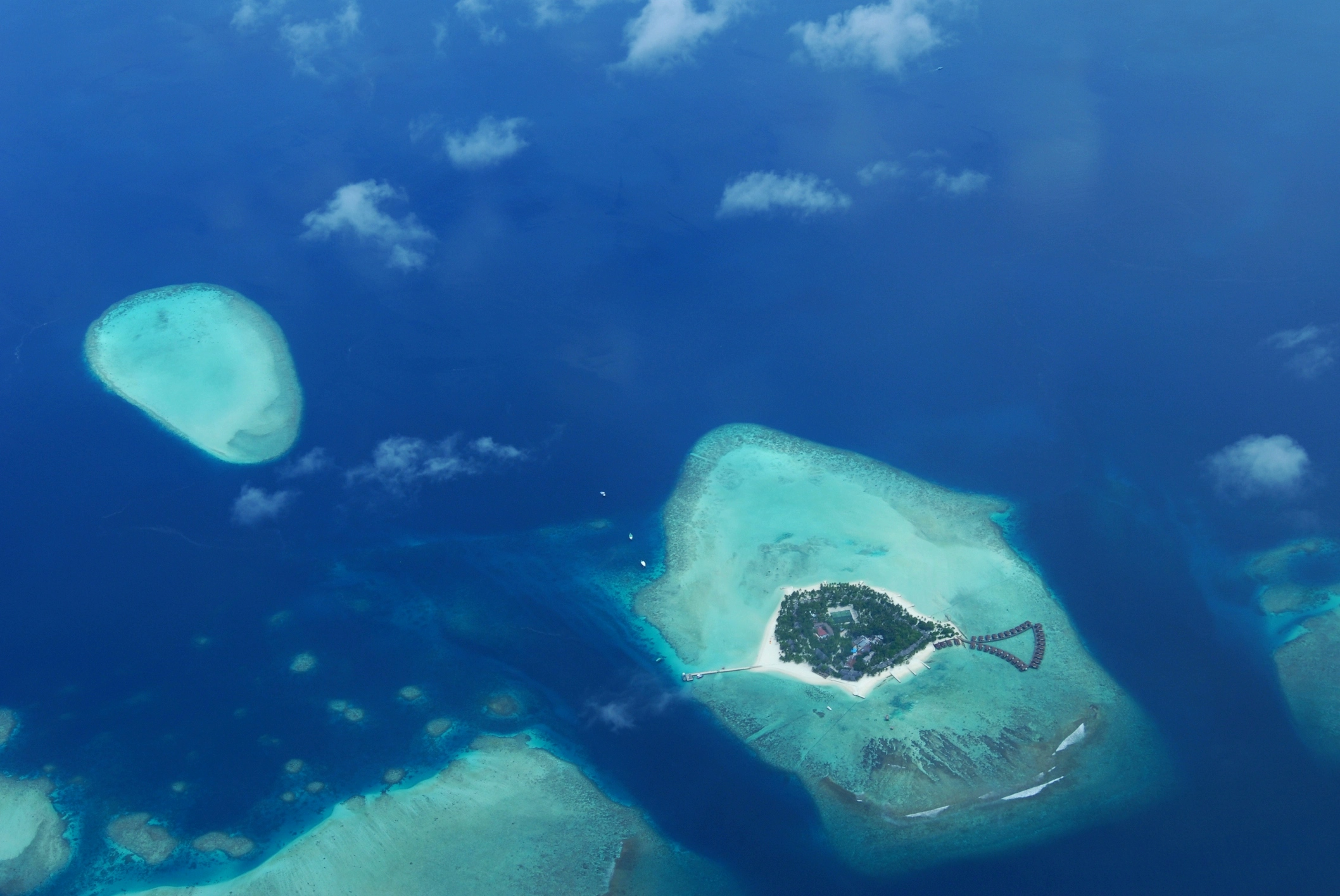 un atollo delle maldive circondato da spiaggia candida nell'oceano indiano