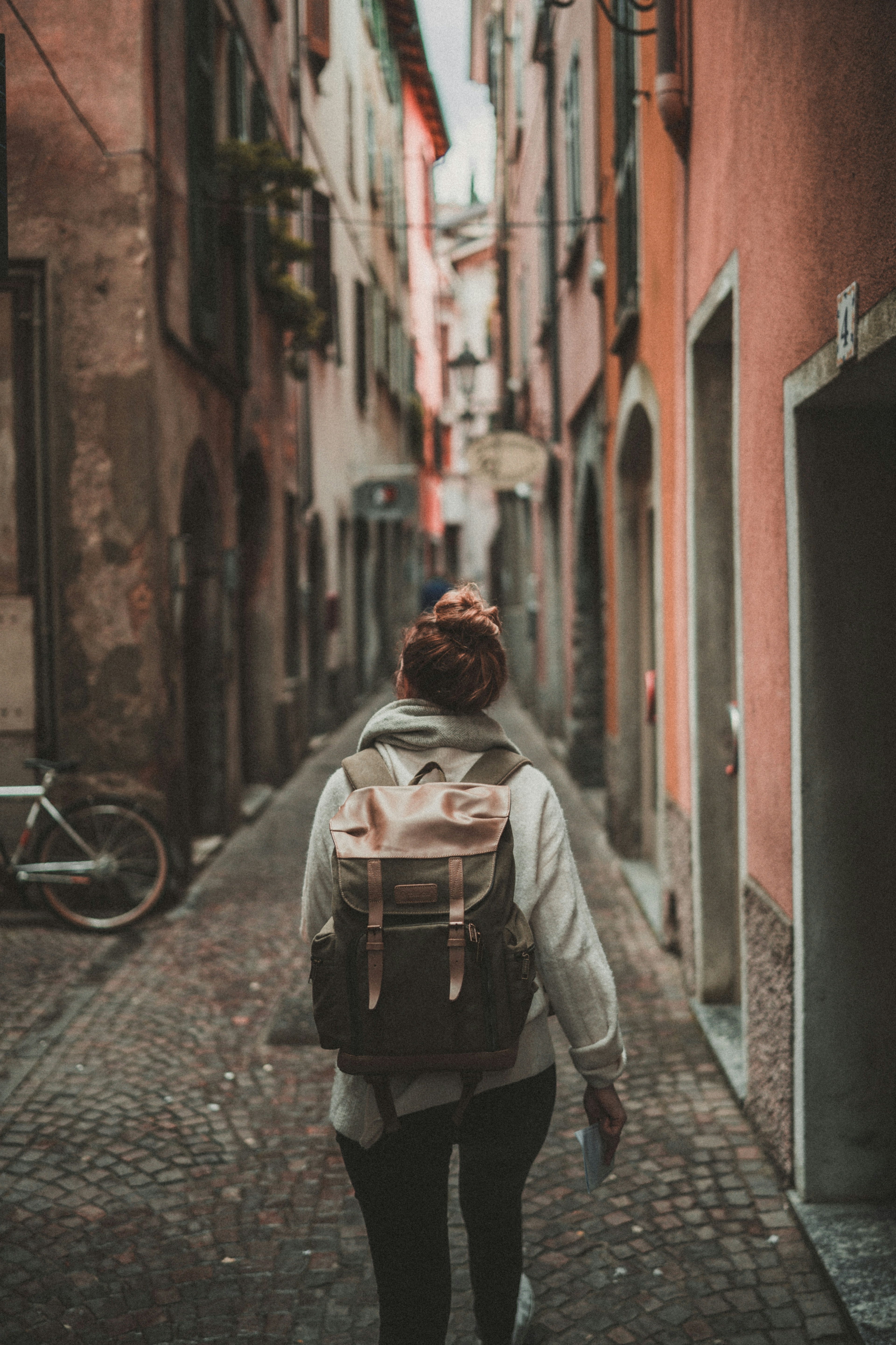 Una ragazza con uno zainetto cammina per le vie di una vecchia città (informazioni utili e consigli di viaggio per maiorca)