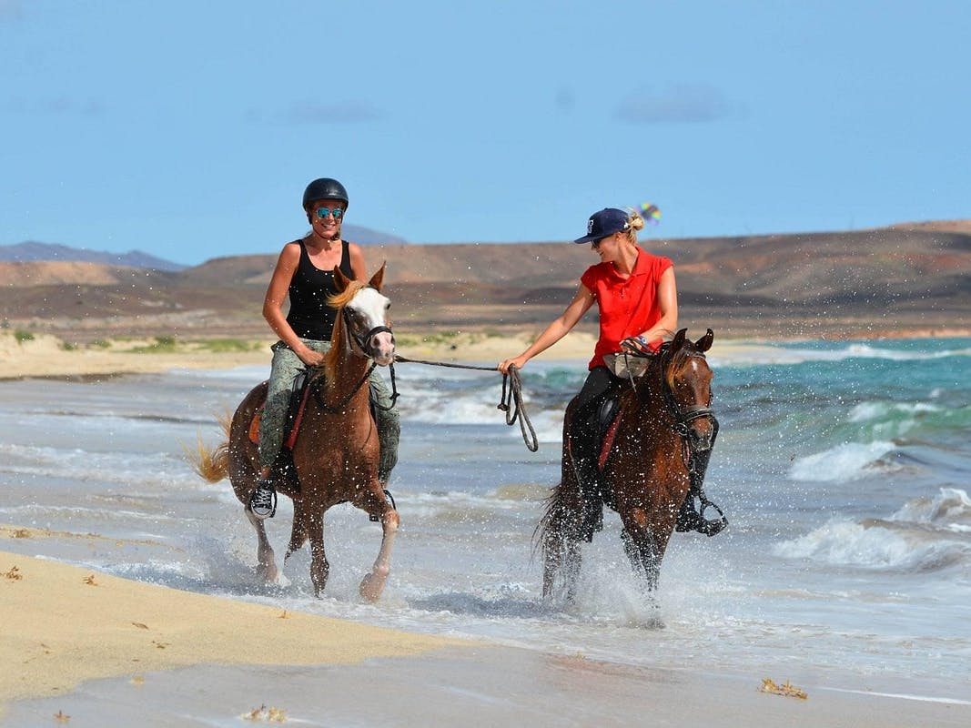 Ragazze che cavalcano sulla spiaggia tra le saline di Santa Maria