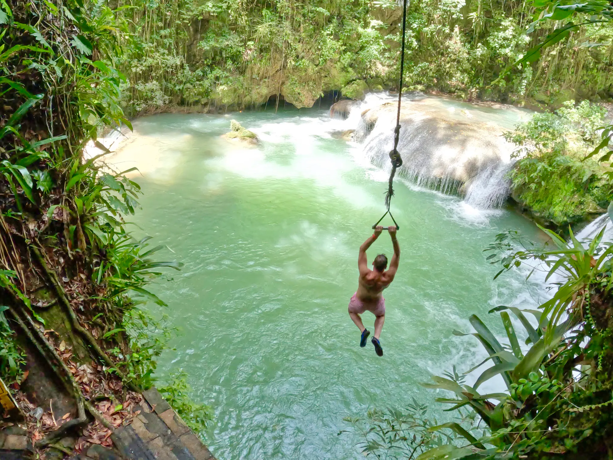 ragazzo che si lancia da una fune dalle cascate di YS