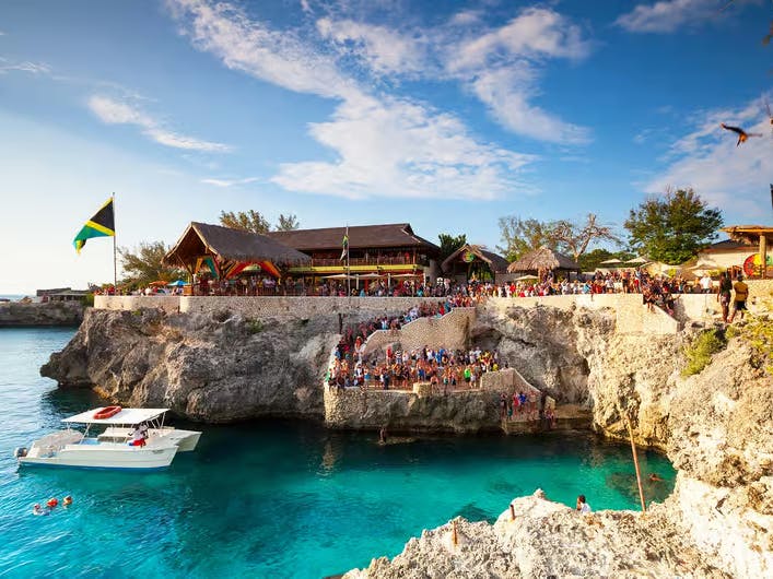 Gruppo di persone che osserva tuffatori lanciarsi in piscina naturale