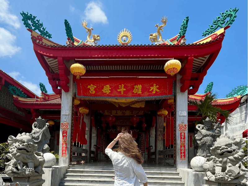 Ragazza di spalle davanti ad un tempio della città di Phuket