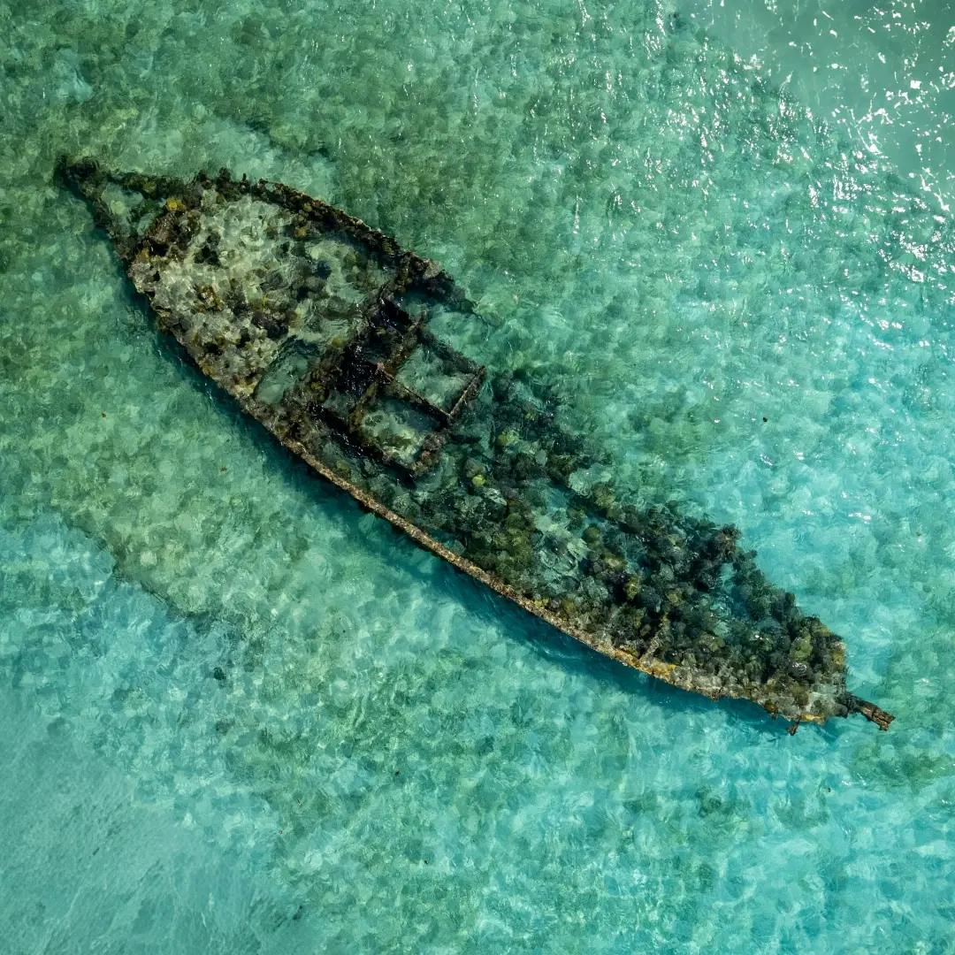 relitto di una nave abbandonata sommerso dall'acqua cristallina