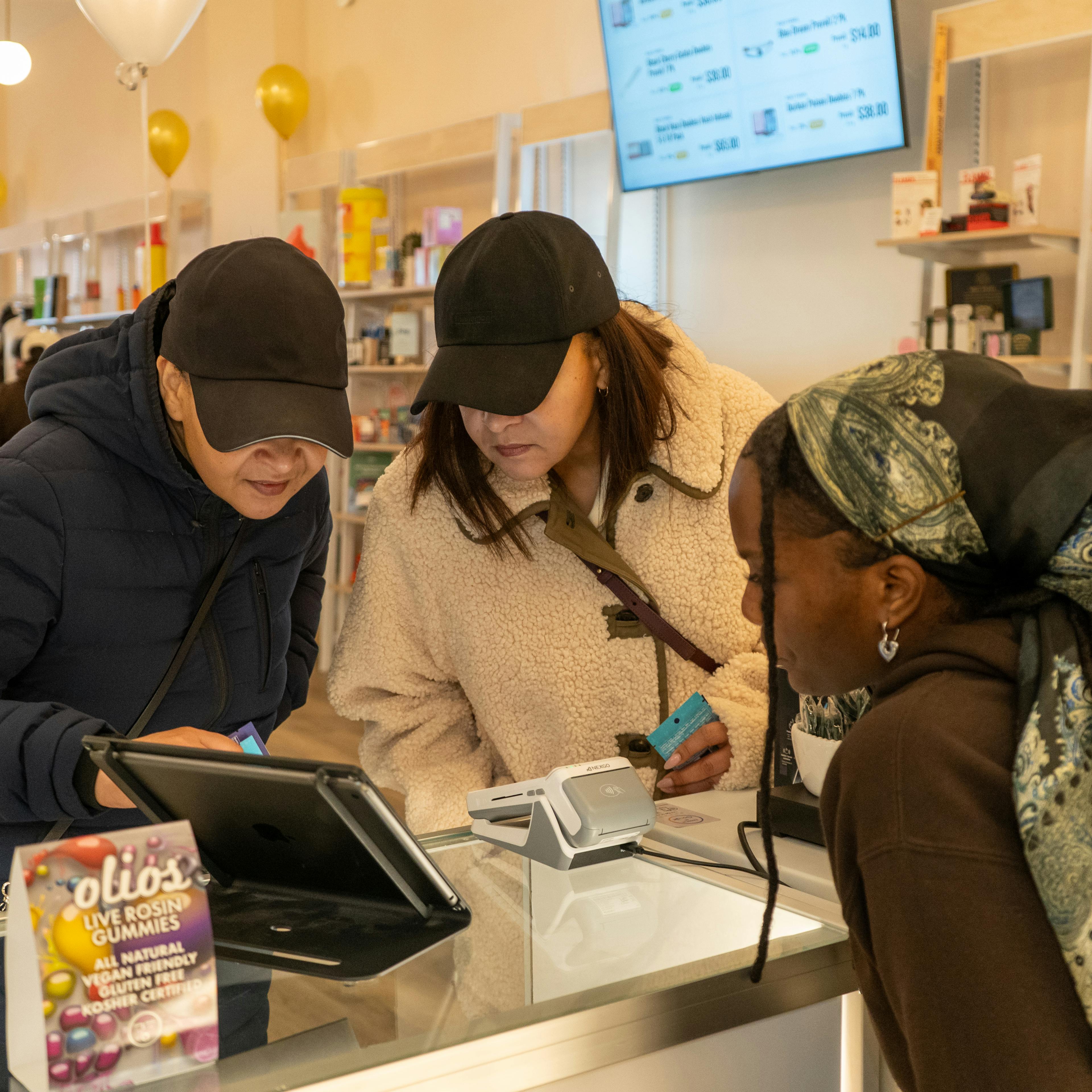 Bliss and Lex budtender guiding two customers through the store menu. 