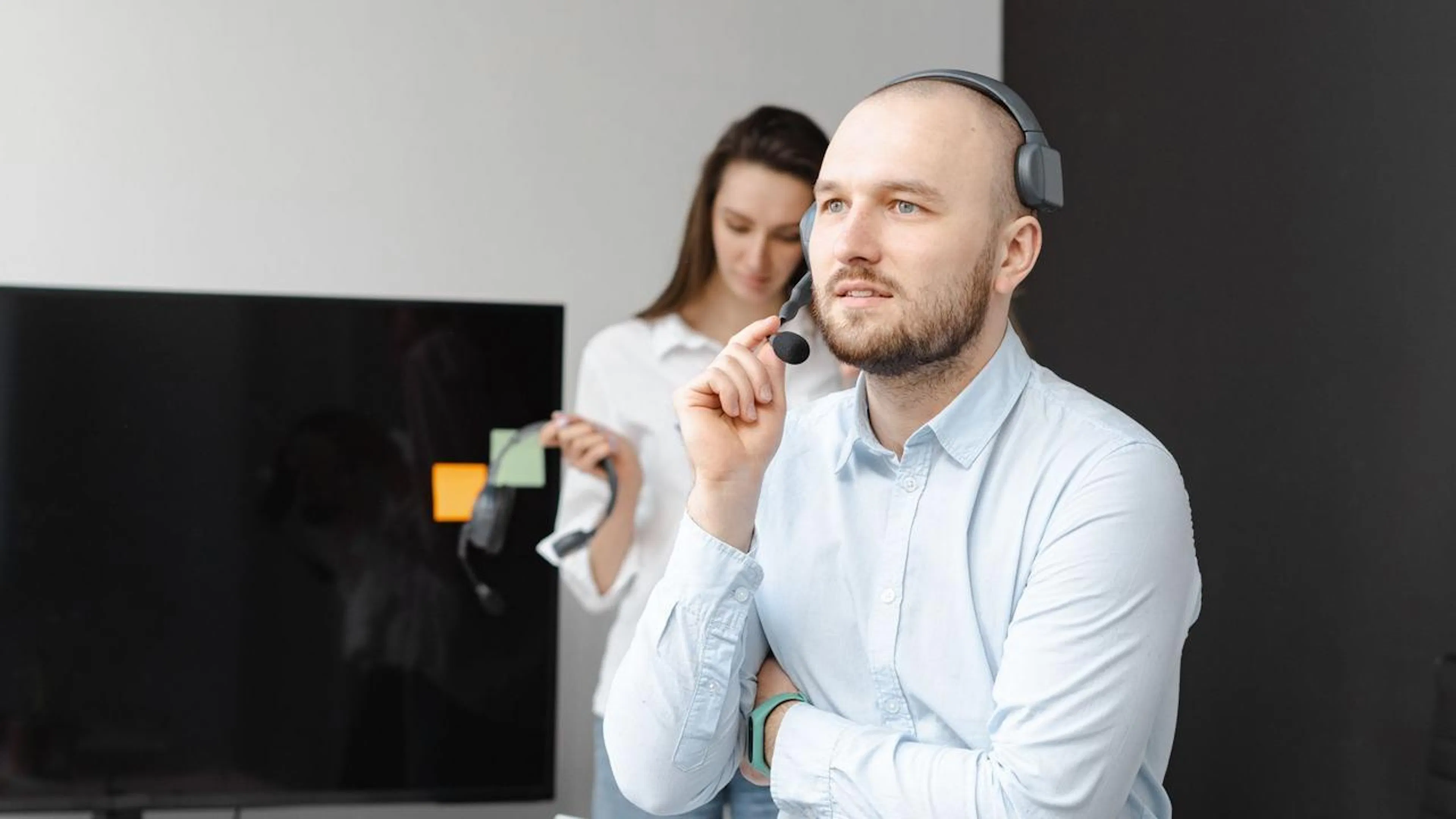Equipe de atendimento ao cliente trabalhando em um escritório moderno, usando ferramentas digitais e um assistente de IA para otimizar o suporte.