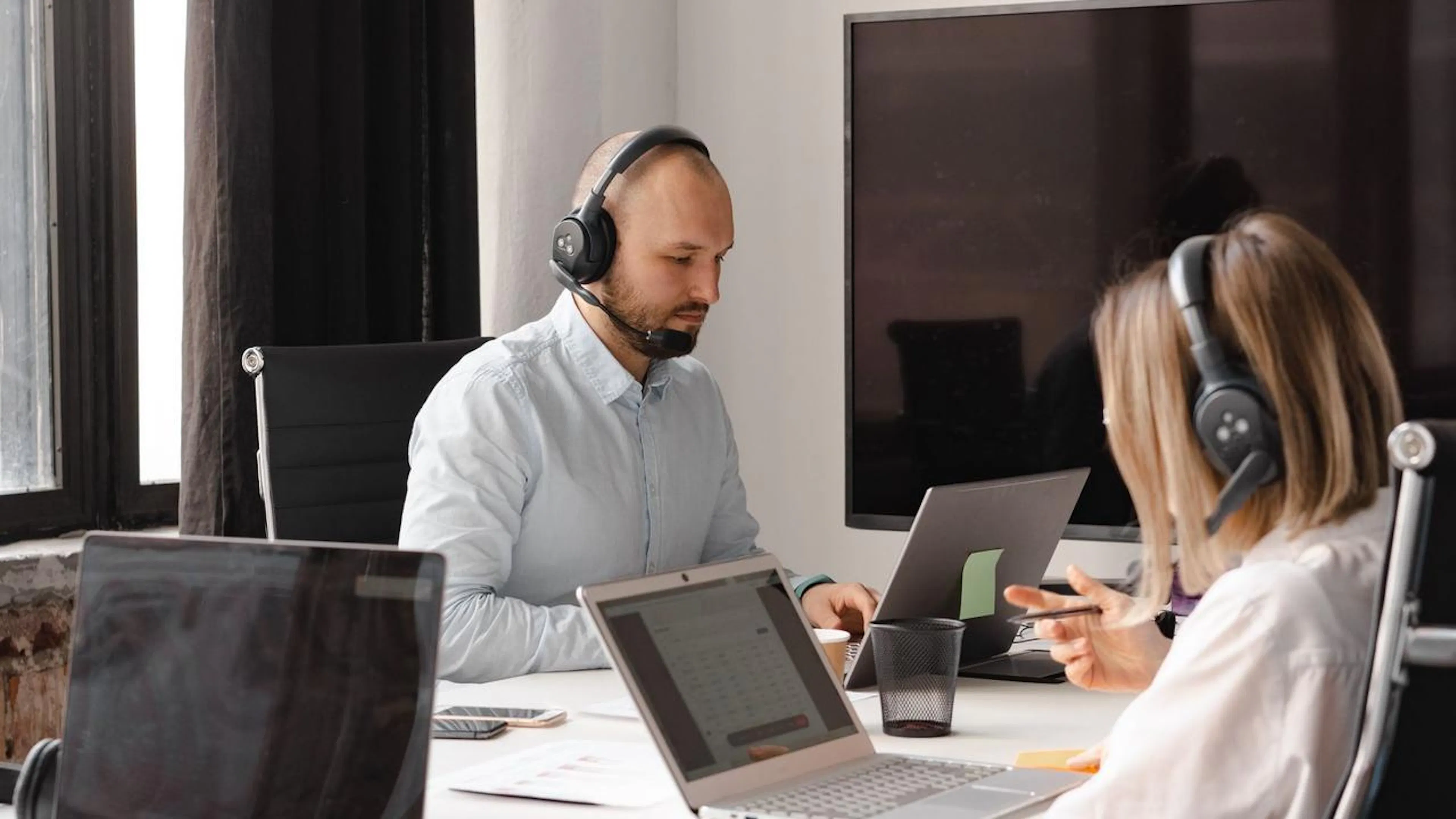 Um agente de atendimento humano colaborando com um assistente virtual de IA, mostrando a organização das conversas em uma interface moderna.