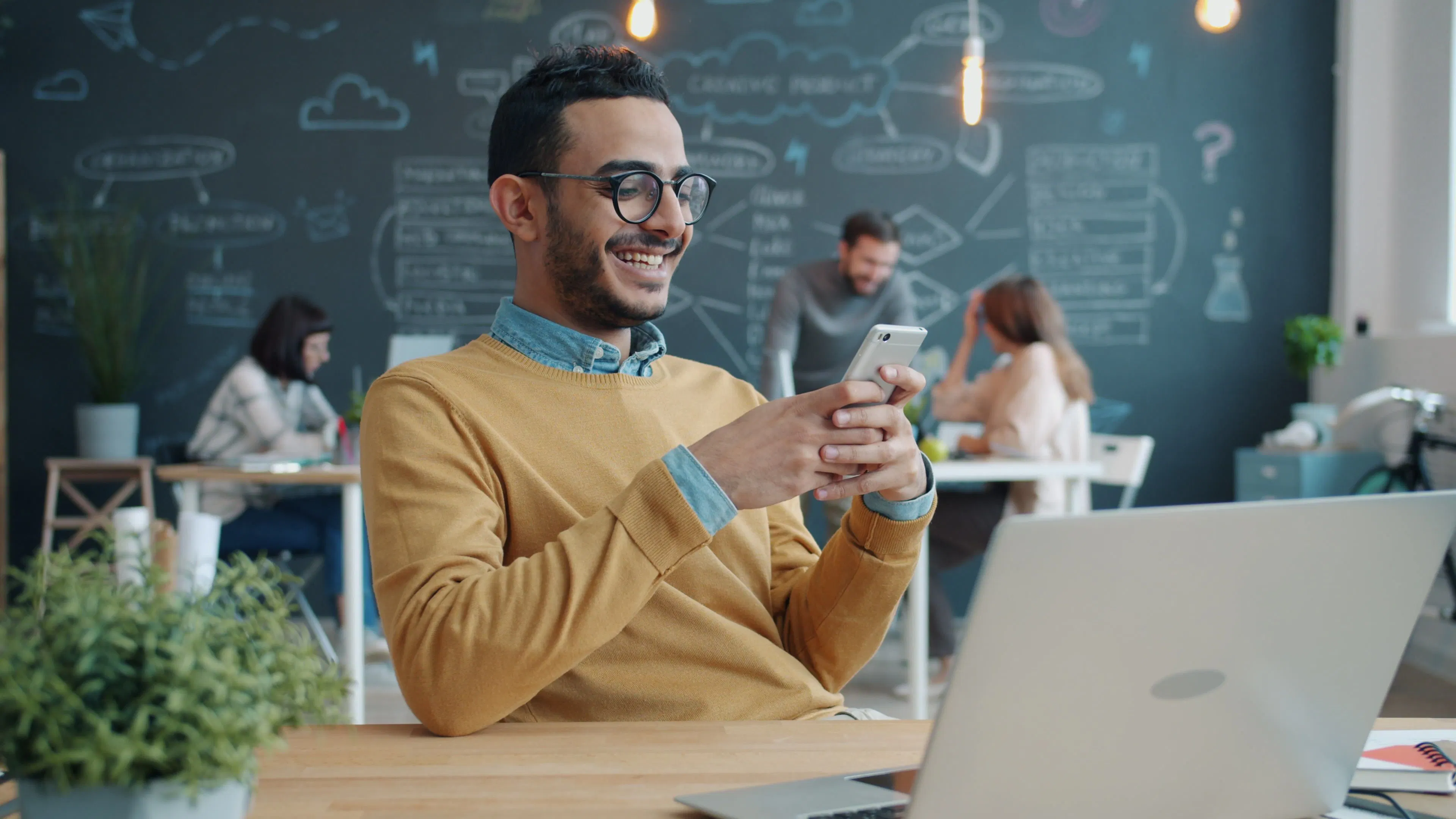 Pequena empresa utilizando celular e notebook para atendimento pelo WhatsApp com apoio de inteligência artificial
