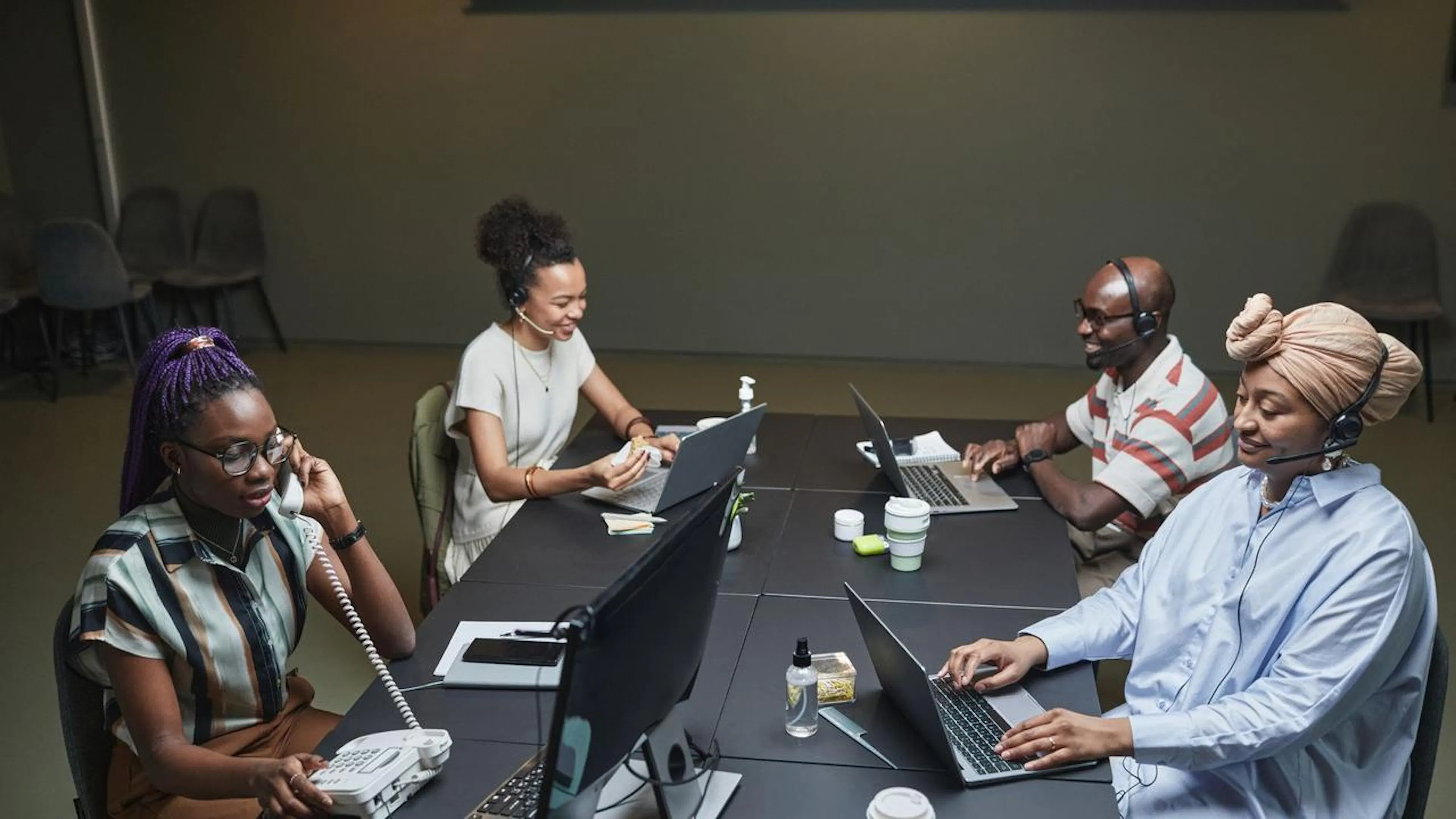 Equipe de atendimento ao cliente colaborando e usando tecnologia para gerenciar comunicações digitais e garantir a satisfação.