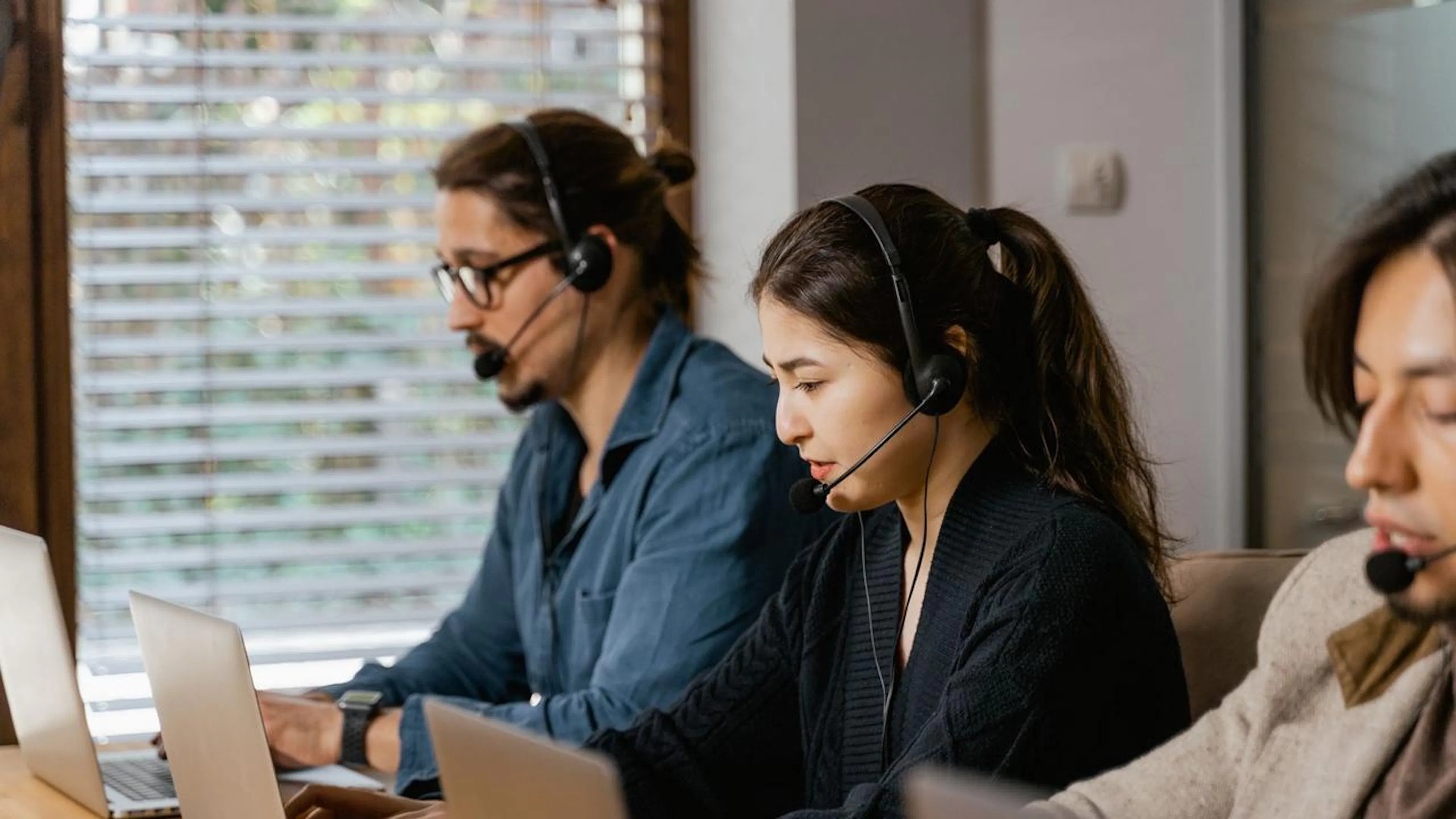 Uma equipe de suporte ao cliente trabalhando em conjunto com um assistente de IA em uma tela, otimizando o fluxo de trabalho de comunicação.