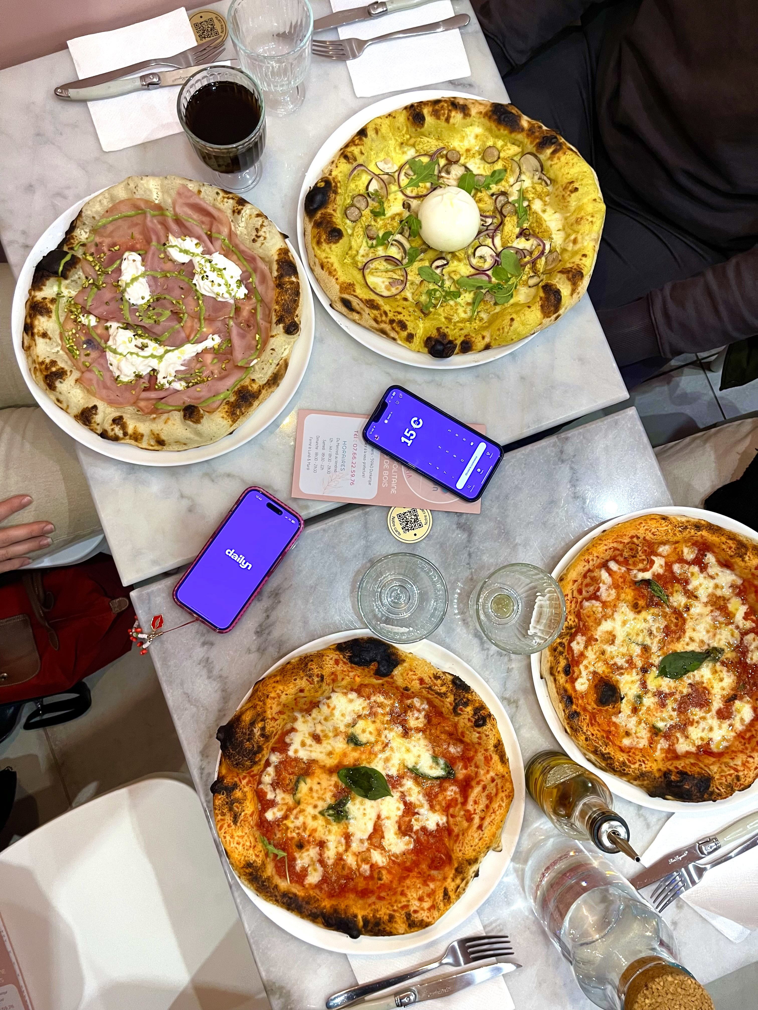 Quatre pizzas sur une table