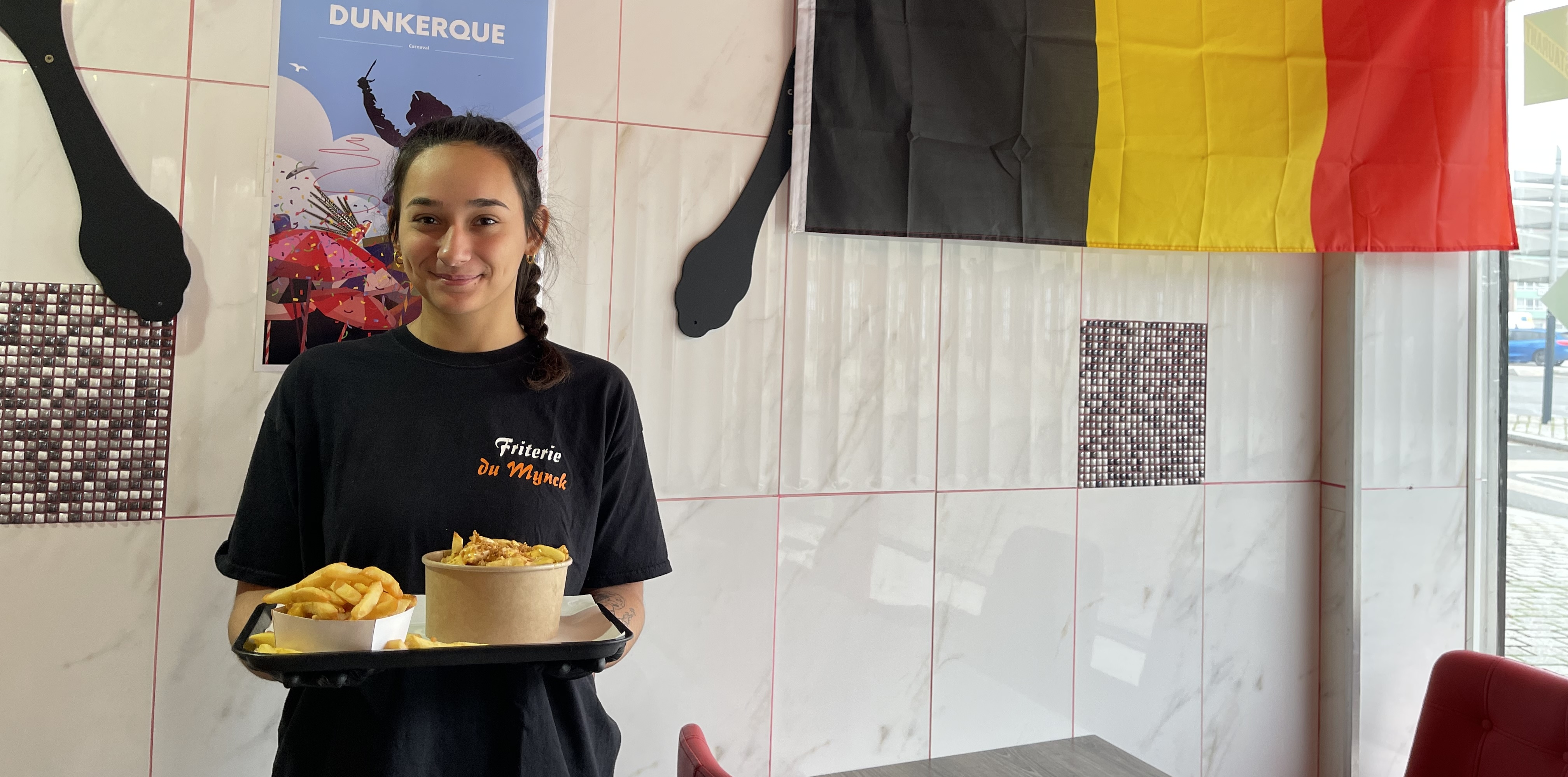 Une jeune femme dans un restaurant avec un plateau de nourriture dans la main