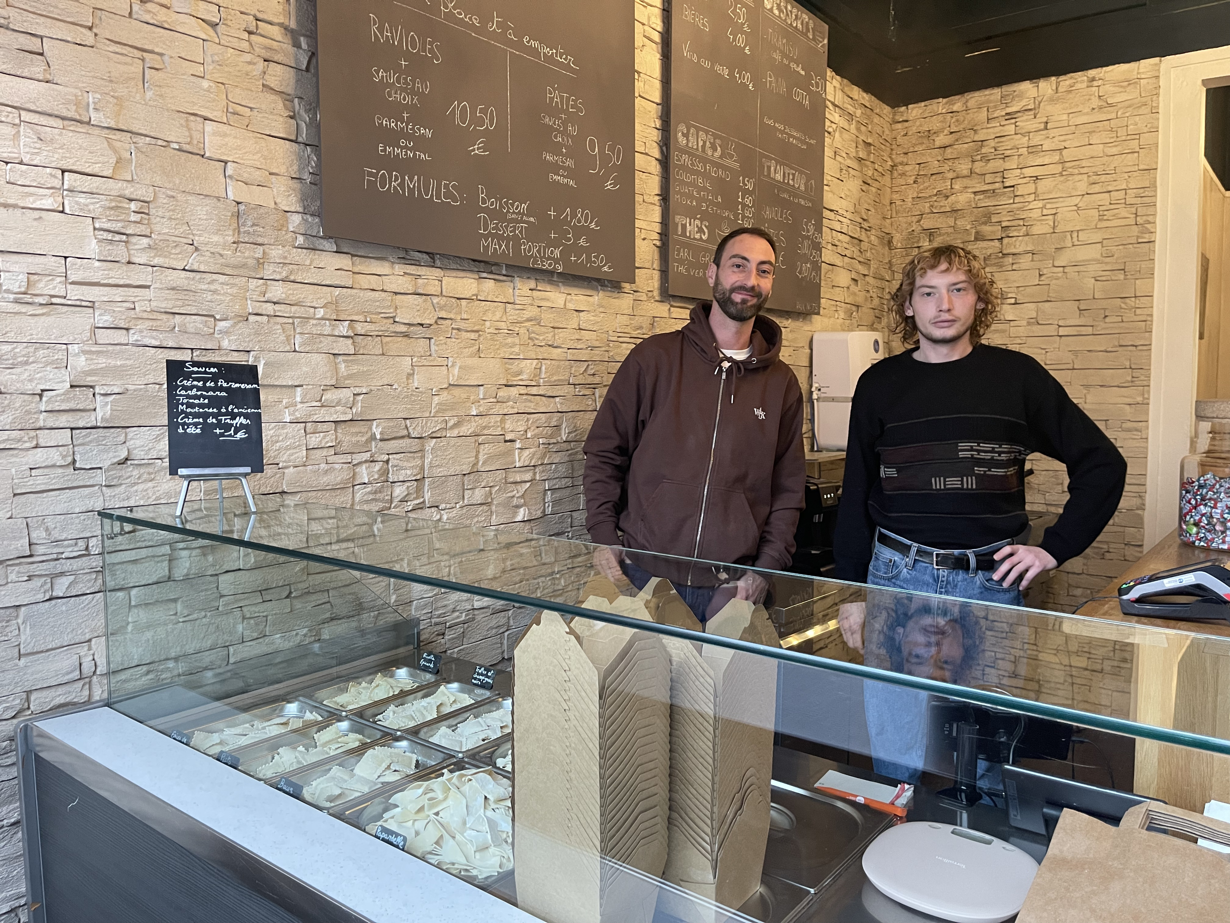 2 hommes derrière un comptoir de restaurant