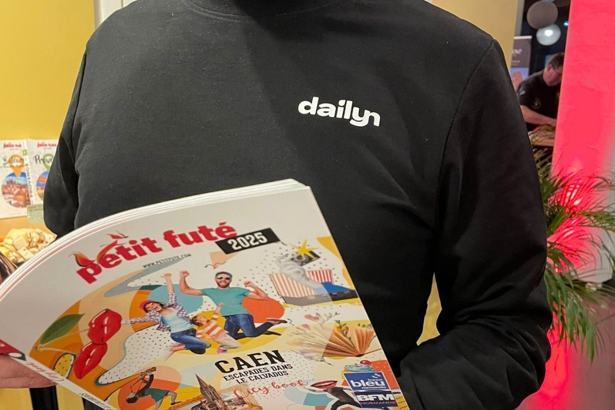 Un homme avec un sweat noir lit un magazine