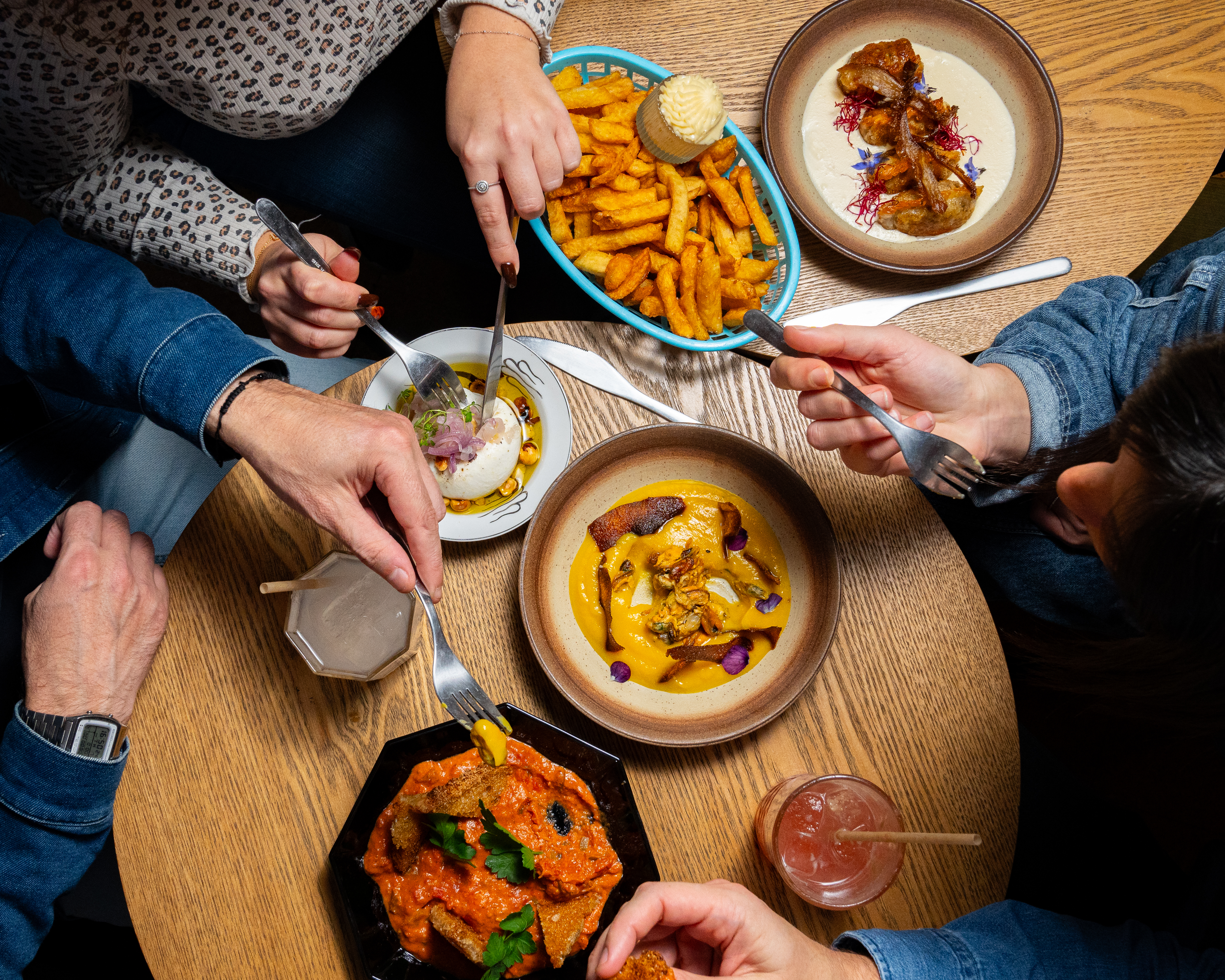 Des plats colorés disposés sur une table en bois