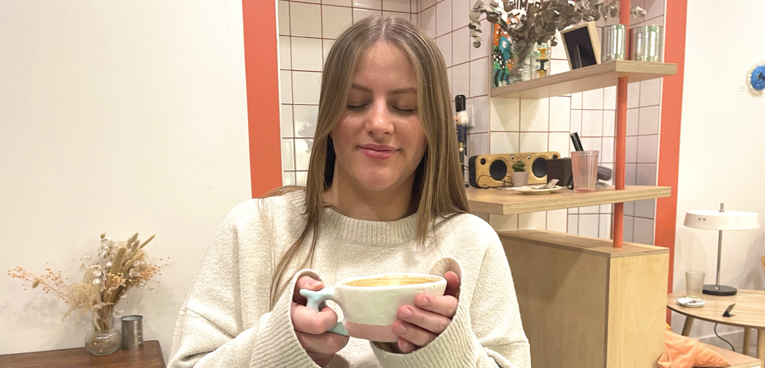 Une personne boit dans une tasse blanche