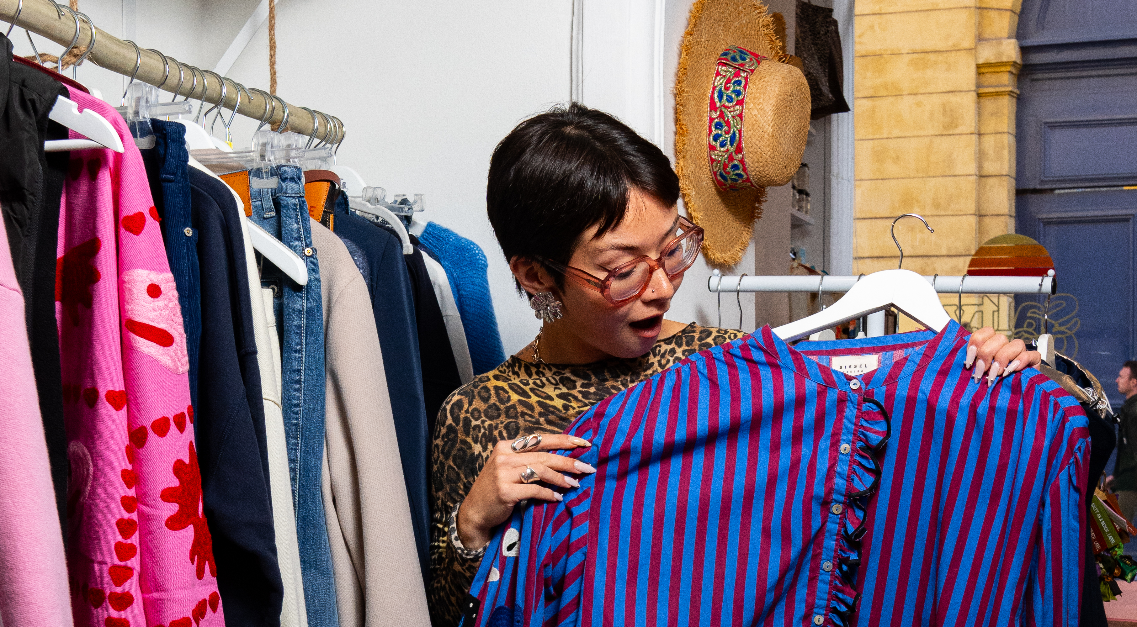 Une fille regarde une chemise dans un magasin de vêtement
