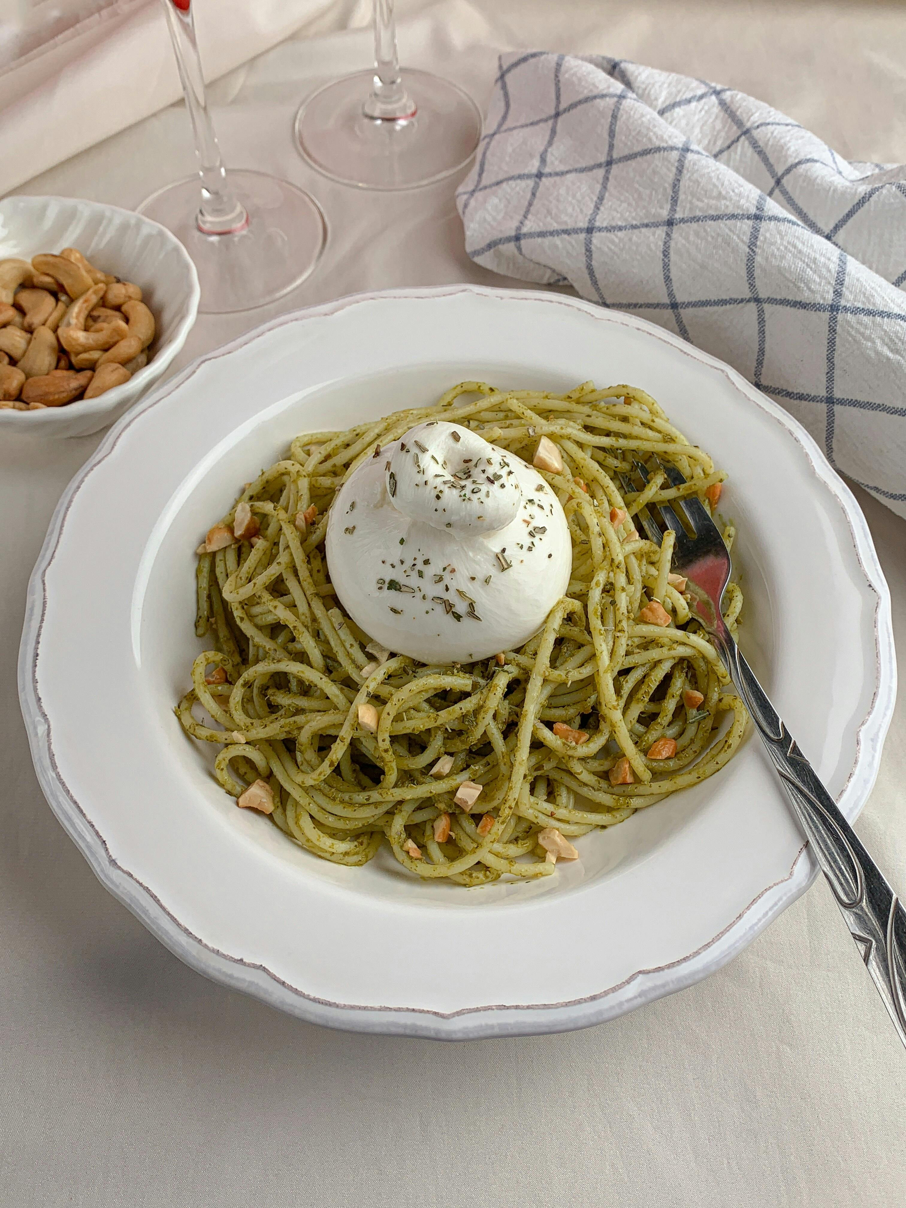 Un plat de pĂątes italienne sauce pesto avec une burrata