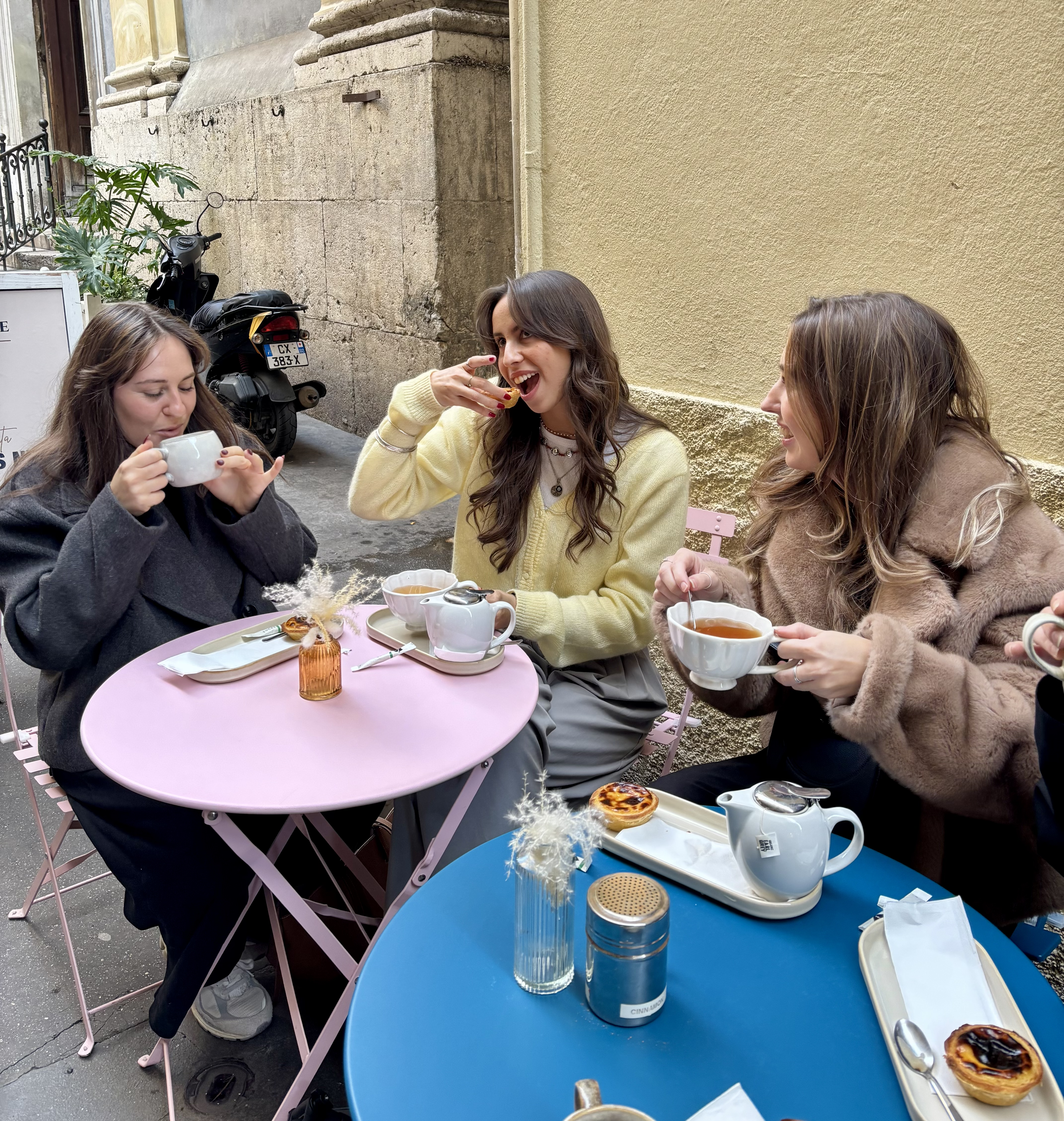 Trois femmes autour d'une table buvant et mangeant