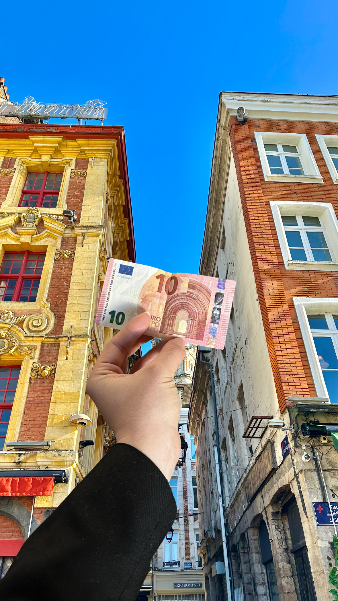 Une main qui tient un billet de 10€